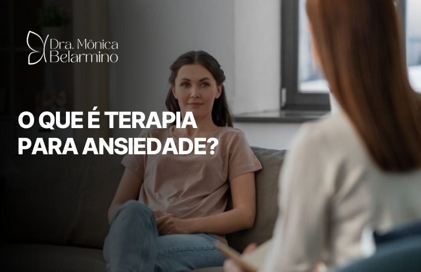 Mulher sentada em consultório psicológico durante sessão com terapeuta. Ao lado, o texto “O que é terapia para ansiedade?” e o logotipo da Dra. Mônica Belarmino. A imagem representa o acolhimento e o início do processo terapêutico voltado ao tratamento da ansiedade.