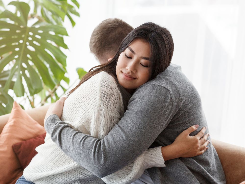 Casal se abraçando com carinho e empatia, simbolizando a importância do afeto e da compreensão em o que é mais importante em um relacionamento.